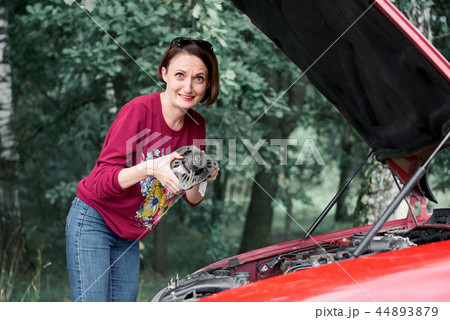 a young girl stands at a broken car a young girl stands at a broken car 44893879