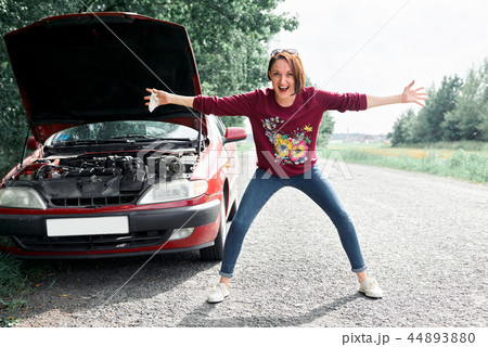 a young girl stands at a broken car a young girl stands at a broken car 44893880