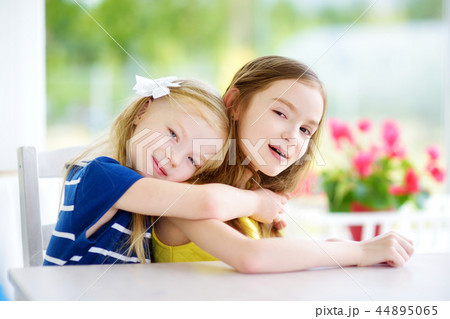 Portrait of two cute little sisters at home on beautiful summer day Portrait of two cute little sisters at home on beautiful summer day 44895065