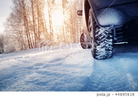 Car tires on winter road covered with snow 44895616
