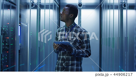 Ethnic IT specialist with tablet in server room Ethnic IT specialist with tablet in server room 44906217