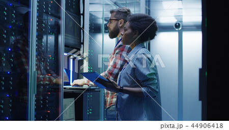 Diverse IT colleagues setting server hardware Diverse IT colleagues setting server hardware 44906418
