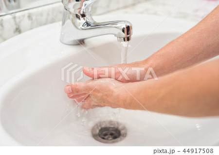 Young woman washing her hands 44917508