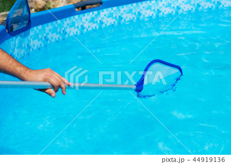 Backyard garden swimming pool cleaning close up 44919136