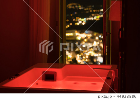 Luxury travel Santorini vacation hotel jacuzzi in colored lights with night view of the city. 44923886