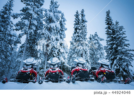 Row of red and black snowmobiles in winter Lapland Row of red and black snowmobiles in winter Lapland 44924046