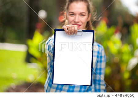Woman in shirt is holding landscape white sheet Woman in shirt is holding landscape white sheet 44924050
