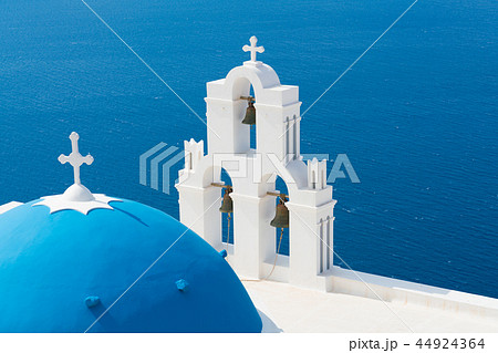 sunset over aegean sea with view to Virgin Mary Catholic Church Three Bells of Fira, Santorini. 44924364