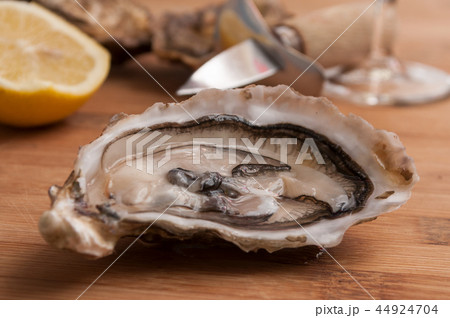 oysters and lemon on wooden cutting board 44924704