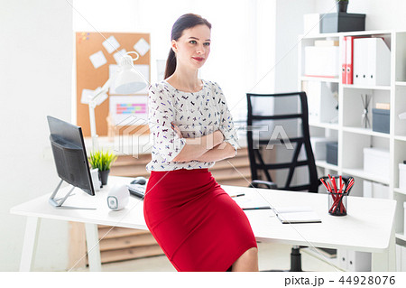 A young girl sat down on a table in the office. A young girl sat down on a table in the office. 44928076