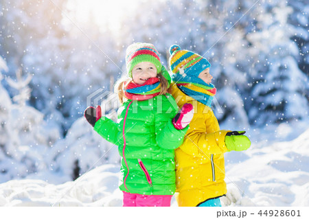 Child playing with snow in winter. Kids outdoors. 44928601