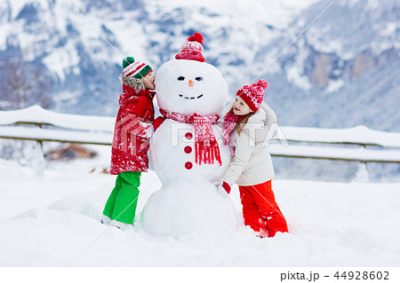 Child building snowman. Kids build snow man. Child building snowman. Kids build snow man. 44928602