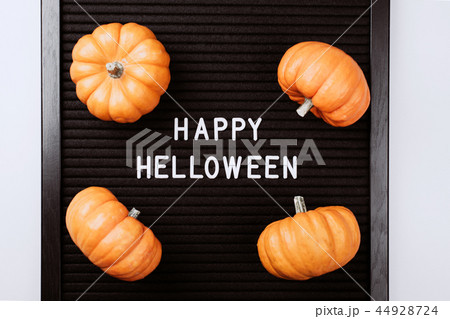 Happy Halloween words on black letter board in frame with pumpkins. 44928724