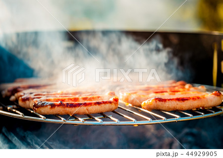 BBQ with fiery sausages on the grill 44929905