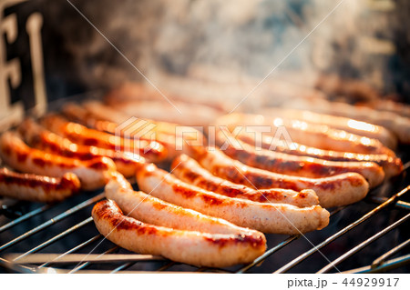 BBQ with fiery sausages on the grill 44929917
