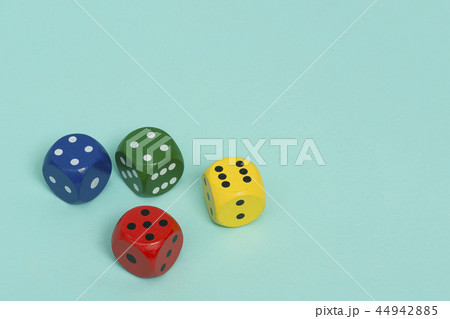 Four colorful gaming dices on a blue background Four colorful gaming dices on a blue background 44942885