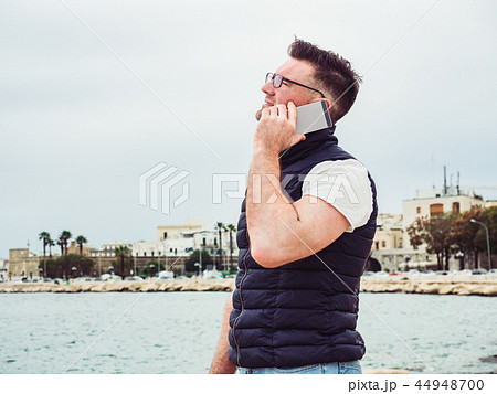 Stylish, happy man with a phone on the background of a sea 44948700