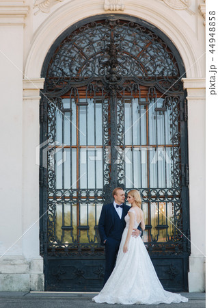Groom and bride neat the big door of great palace 44948858