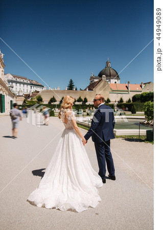 Beautiful young bride with her handsome groom walking in palace Belvedere Beautiful young bride with her handsome groom walking in palace Belvedere 44949089