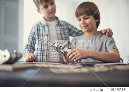 Cheerful boy holding toy car while his brother standing near Cheerful boy holding toy car while his brother standing near 44949783