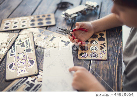 Attentive boy checking the pattern while sitting with constructor 44950054