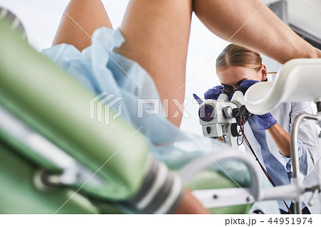 Young doctor working with colposcope during pelvic exam 44951974
