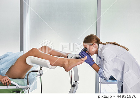 Highly qualified doctor doing gynecological examination of female patient 44951976