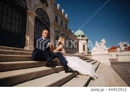 Fashion photo of wedding couple. Groom wears blue suit and tie bow. Bride wears white wedding dress Fashion photo of wedding couple. Groom wears blue suit and tie bow. Bride wears white wedding dress 44952912