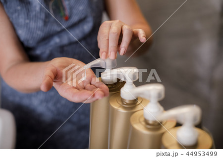 Woman is taking shampoo with batcher in beauty salon 44953499