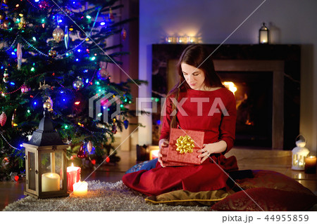 Beautiful woman enjoying her time by a fireplace on Christmas eve 44955859