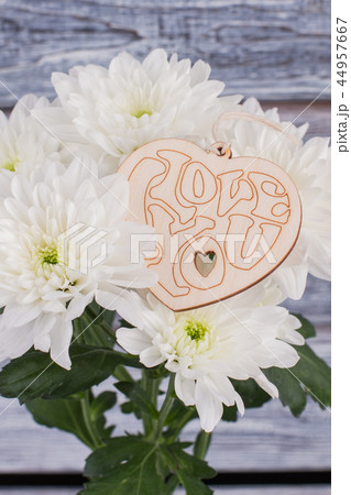 Chrysanthemums and heart-shaped wooden tag. Chrysanthemums and heart-shaped wooden tag. 44957667