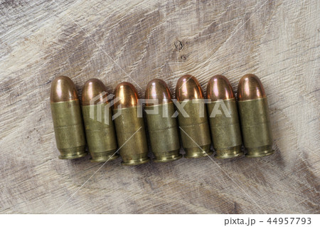 The .45 caliber cartridges on wooden background The .45 caliber cartridges on wooden background 44957793