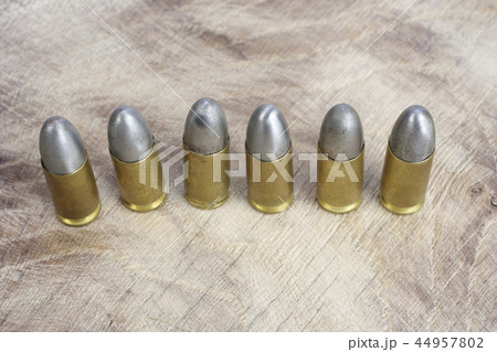 The 9mm caliber cartridges on wooden background 44957802
