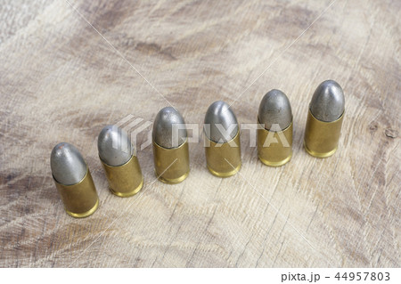 The 9mm caliber cartridges on wooden background 44957803