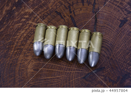 The 9mm caliber cartridges on wooden background 44957804