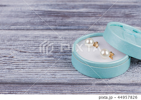 Pair of golden pearl earrings in gift box. Pair of golden pearl earrings in gift box. 44957826