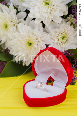 Engagement ring in red box and flowers. 44958294