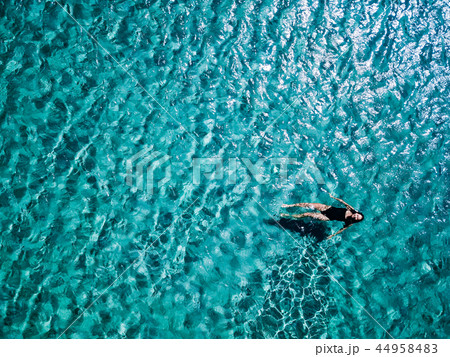 Young girl in a black swimsuit swims in the sea. 44958483