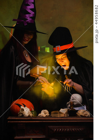 Picture of two witches in black hats making potions Picture of two witches in black hats making potions 44958682