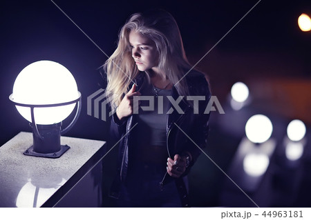 beautiful girl posing in the night city / model adult girl posing in the evening in the city, outdoor at night 44963181