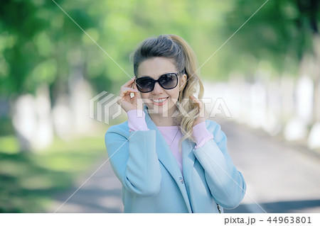 portrait of a european beautiful female model wearing sunglasses / girl outdoors walking, happy cheerful girl wearing glasses 44963801