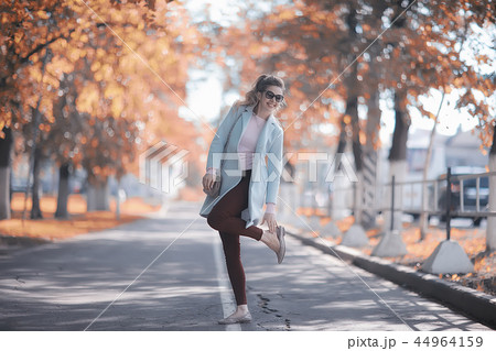 walk in autumn park / beautiful girl in autumn park, model female happiness and fun in yellow trees October 44964159