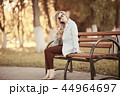 adult girl sitting on a bench in the park / beautiful model woman resting on a bench, cheerful happy girl 44964697