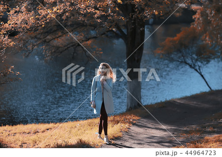 walk in autumn park / beautiful girl in autumn park, model female happiness and fun in yellow trees October 44964723