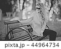 adult girl sitting on a bench in the park / beautiful model woman resting on a bench, cheerful happy girl 44964734