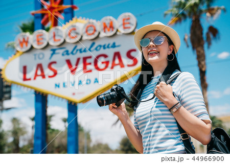female photographer joyfully carrying camera female photographer joyfully carrying camera 44966900