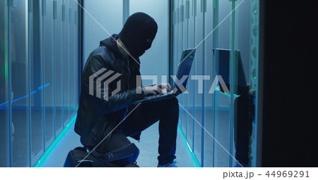 Anonymous hacker breaking into server system Anonymous hacker breaking into server system 44969291