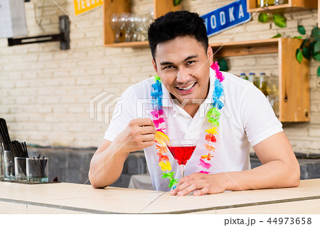 Young man with red cocktail glass Young man with red cocktail glass 44973658