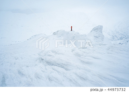 Photographer in winter trekking on snowy mountains Photographer in winter trekking on snowy mountains 44973732