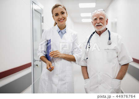 Smiling medical workers posing in hospital hallway Smiling medical workers posing in hospital hallway 44976764